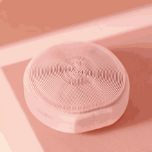 Load image into Gallery viewer, Zobelle Facial Cleansing Brush with EMS and LED light therapy in soft pink color on a matching pink surface
